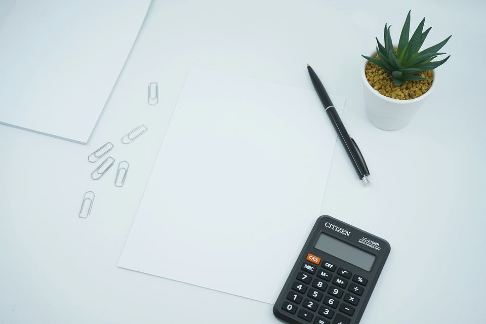 Calculator, pen and paperwork on a desk